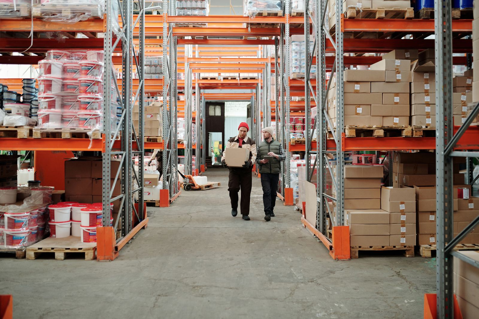 Distribution warehouse aisle with palletised stock being picked for dispatch